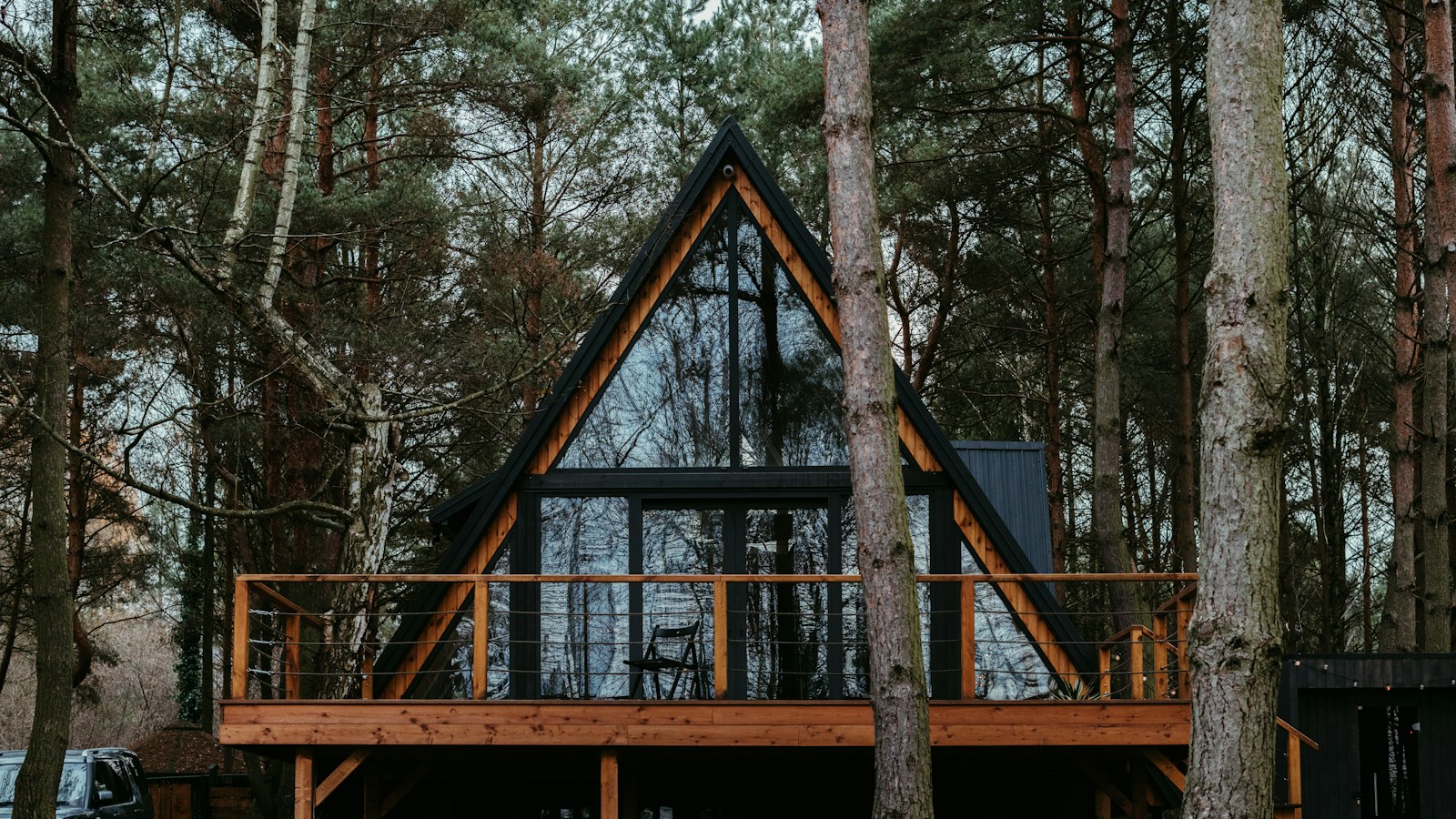 Cabane en bois en forme de A nichée dans la forêt des Alpes au crépuscule
