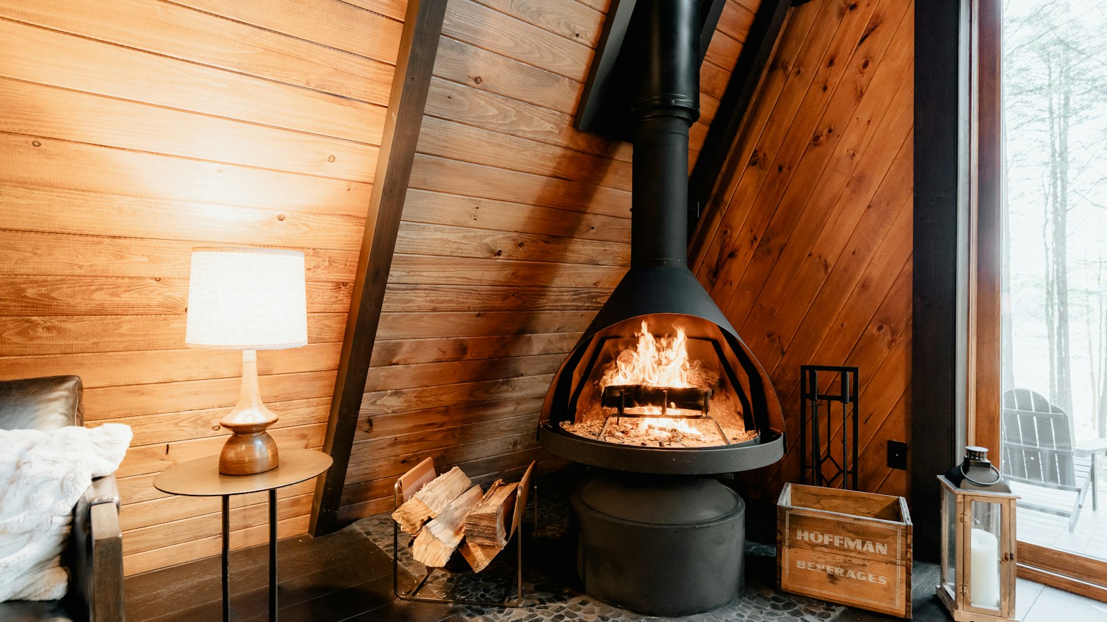 Intérieur chaleureux d'un hébergement en montagne avec poêle à bois allumé, idéal pour les soirées d'automne